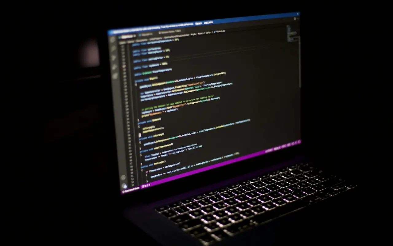 Laptop displaying program code on a desk